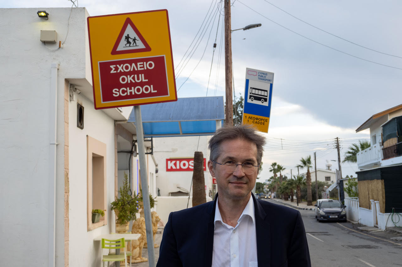 Gerald in Pyla, a mixed village inhabited by Greek and Turkish cypriots in the UN administered buffere zone. The traffic sign drawing attention to the school behind Gerald is in Greek and Turkish (along with English), a rare sight in Cyprus. Photo: Kristof Bender/ESI.